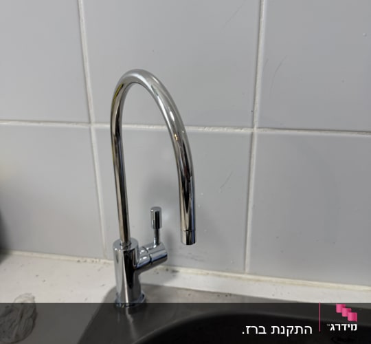 ברז מים מותקן על כיור מטבח עם אריחי קרמיקה
